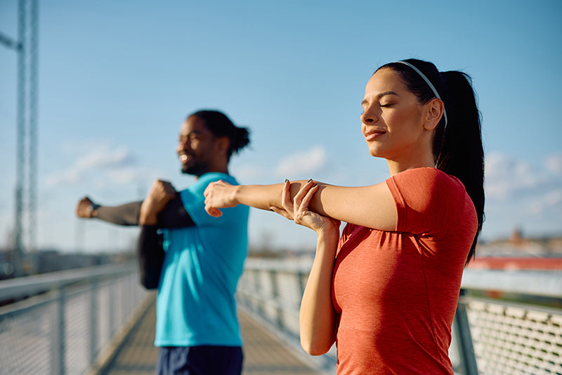 Couple doing cross body shoulder stretching